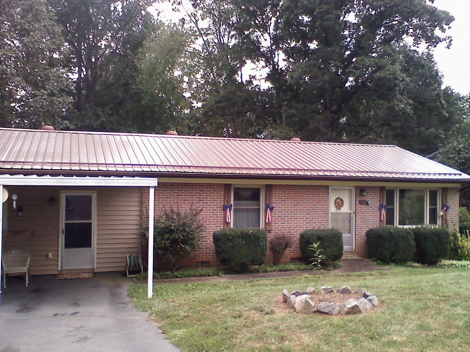 Bronze metal roof and carport on a brick ranch home — Roof Repair work by our crew in La Motte